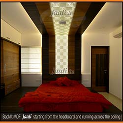 Giving a grand look with a geometrical backlit MDF Jaali starting on the bed back and running along the ceiling at the other end